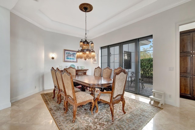 dining area with a tray ceiling, ornamental molding, and a notable chandelier