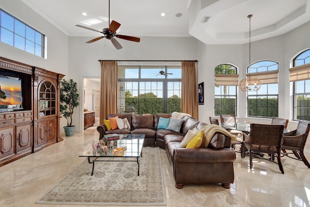 living room featuring crown molding, a towering ceiling, and ceiling fan with notable chandelier