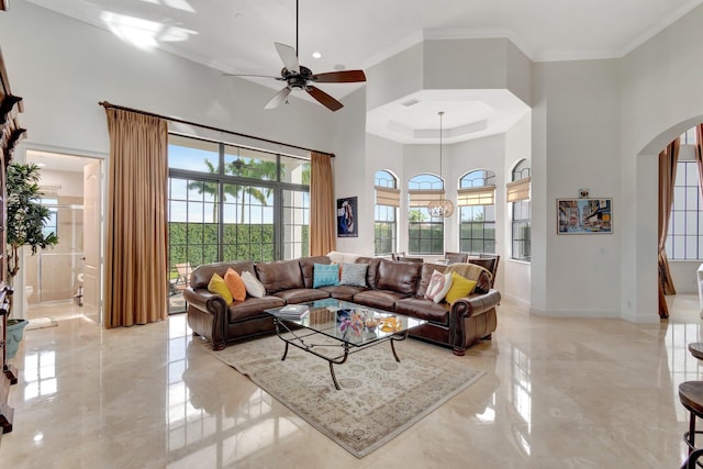 living room featuring a high ceiling, ceiling fan, and a healthy amount of sunlight