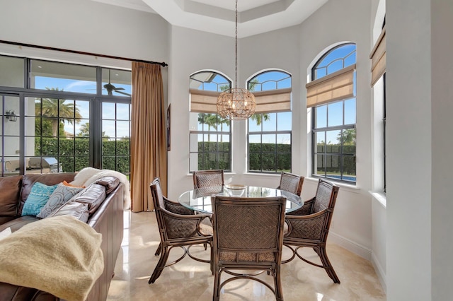 dining space featuring a high ceiling and an inviting chandelier