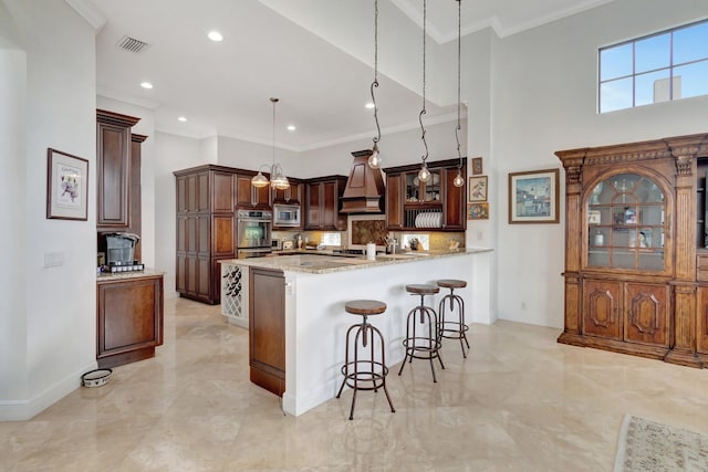 kitchen featuring pendant lighting, stainless steel microwave, light stone countertops, and ornamental molding