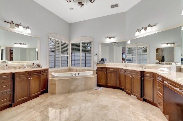 bathroom with vanity and tiled tub