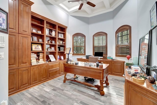 home office featuring beam ceiling, ceiling fan, coffered ceiling, a towering ceiling, and light wood-type flooring