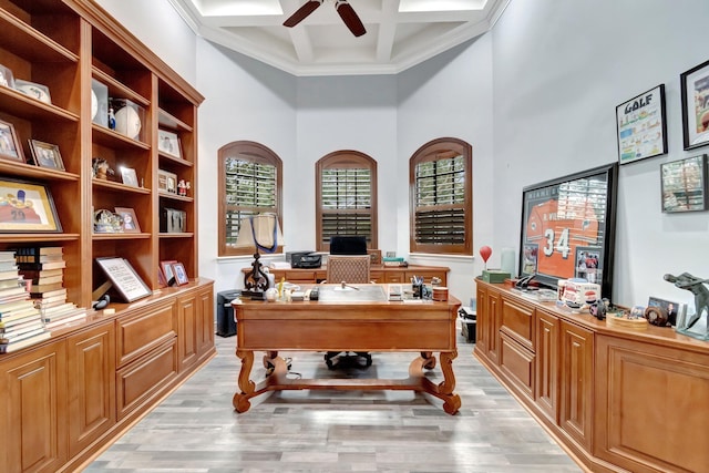 office area with coffered ceiling, light hardwood / wood-style flooring, ceiling fan, a towering ceiling, and beam ceiling