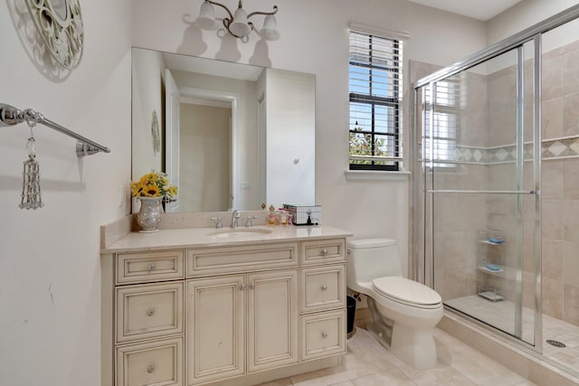 bathroom featuring tile patterned flooring, vanity, a shower with shower door, and toilet