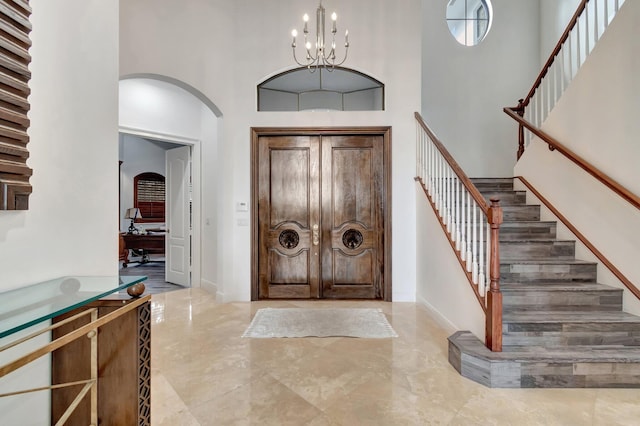 foyer entrance with a chandelier and a high ceiling