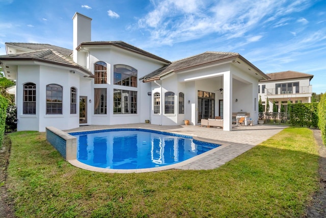 back of house featuring ceiling fan, a patio area, and a lawn