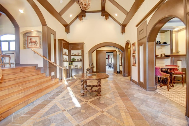 foyer entrance featuring beam ceiling and high vaulted ceiling