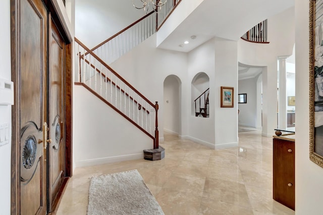 entryway featuring a notable chandelier and a towering ceiling