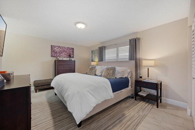 bedroom featuring sink, ensuite bath, and a textured ceiling