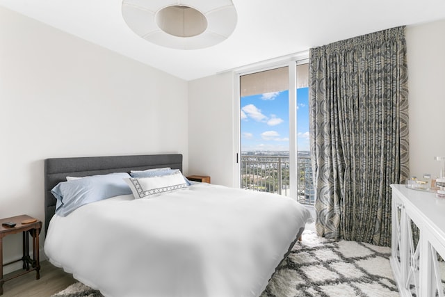 bedroom with light hardwood / wood-style floors and expansive windows