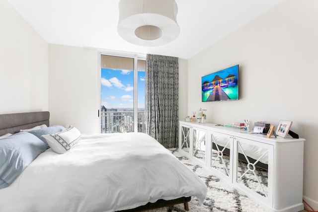 bedroom featuring expansive windows and access to exterior