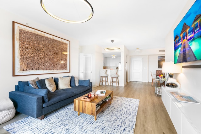 living room featuring light wood-type flooring and ceiling fan