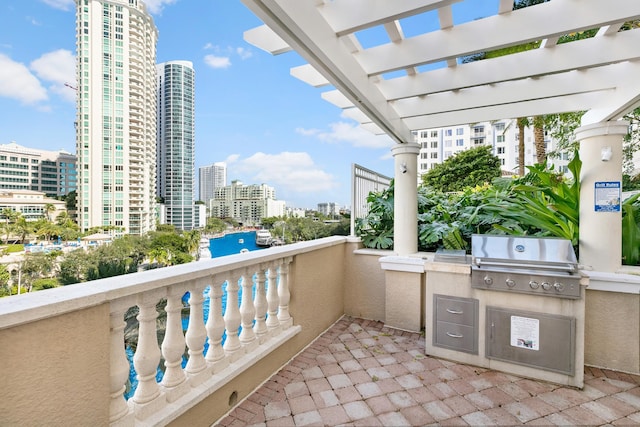 balcony featuring a grill, an outdoor kitchen, and a pergola