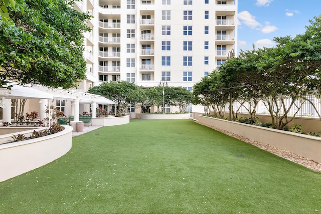 surrounding community featuring a pergola and a lawn