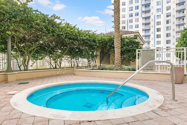 view of swimming pool featuring a hot tub