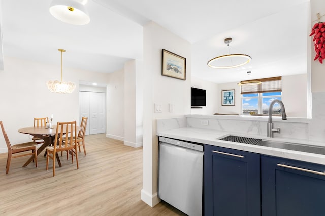 kitchen featuring pendant lighting, stainless steel dishwasher, sink, light wood-type flooring, and blue cabinetry