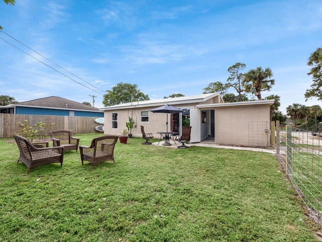 rear view of house with a patio area and a lawn