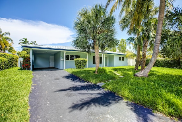 ranch-style home with a carport and a front lawn