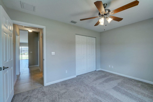 unfurnished bedroom featuring carpet, a closet, and ceiling fan