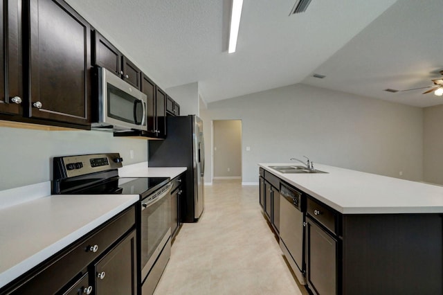 kitchen featuring appliances with stainless steel finishes, ceiling fan, sink, lofted ceiling, and an island with sink