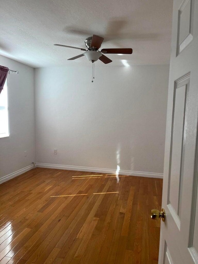 empty room with hardwood / wood-style flooring and ceiling fan