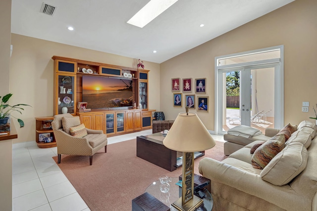 living room with light tile patterned floors, lofted ceiling with skylight, and french doors