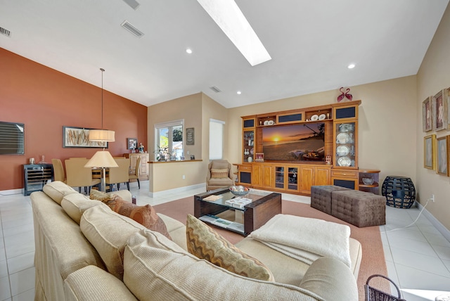 living room with vaulted ceiling with skylight and light tile patterned flooring