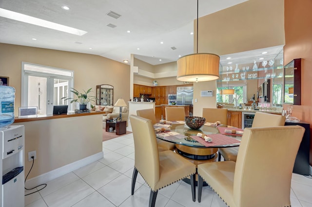 tiled dining space featuring vaulted ceiling, wine cooler, and french doors