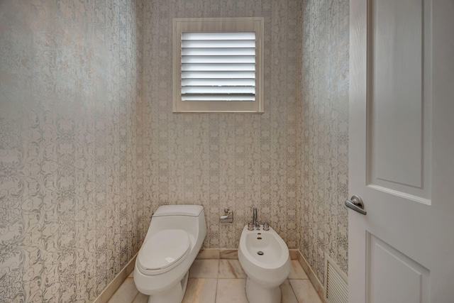 bathroom featuring a bidet, tile patterned floors, and toilet