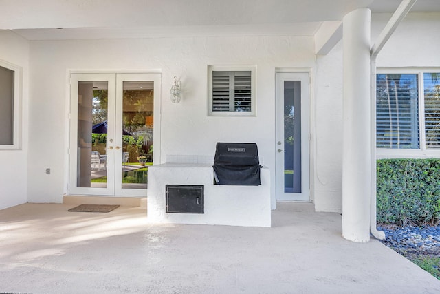 view of exterior entry with french doors and a patio area