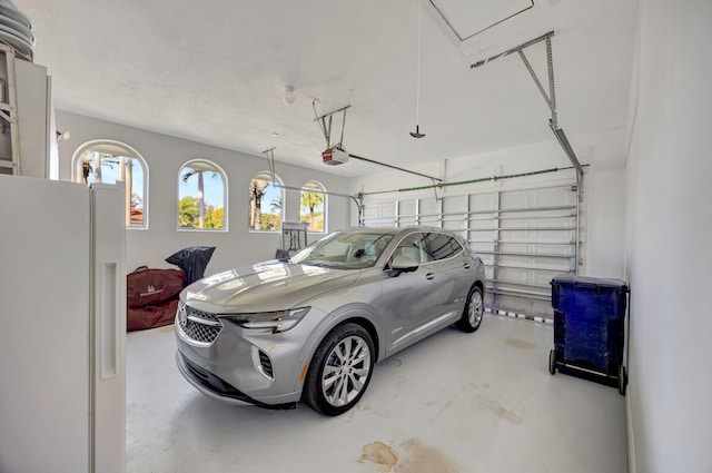 garage featuring a garage door opener and white fridge with ice dispenser