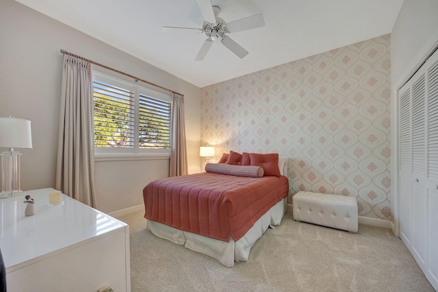 bedroom with light colored carpet, a closet, and ceiling fan