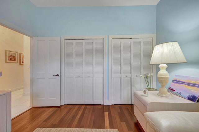 bedroom with two closets and hardwood / wood-style flooring