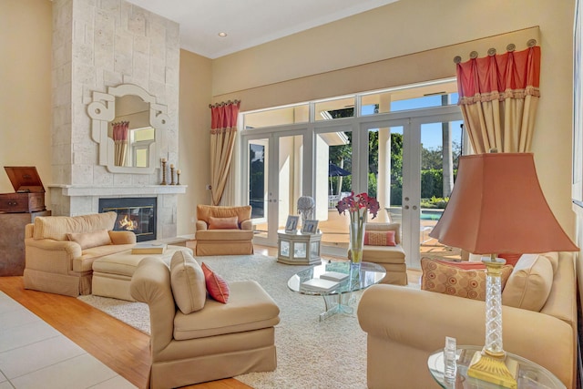 living room with french doors, a large fireplace, and a towering ceiling