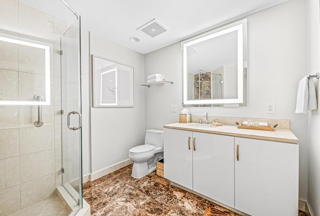 bathroom with vanity, toilet, and a shower with shower door