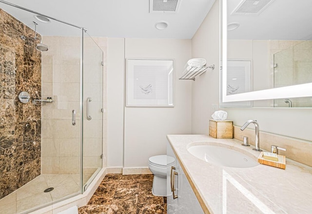 bathroom featuring vanity, toilet, and a shower with door