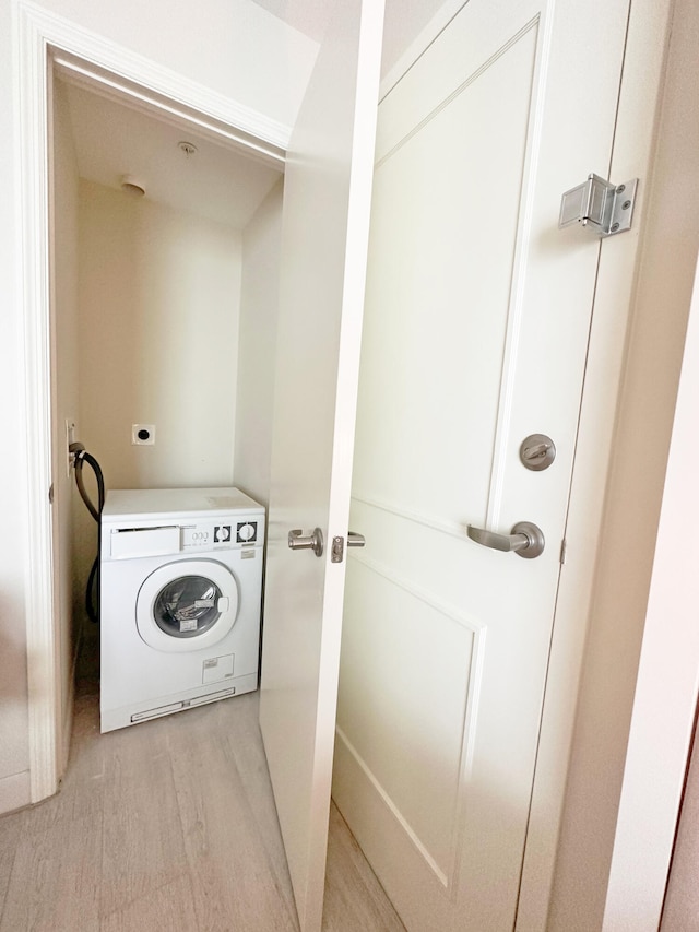 washroom with washer / dryer and light hardwood / wood-style flooring