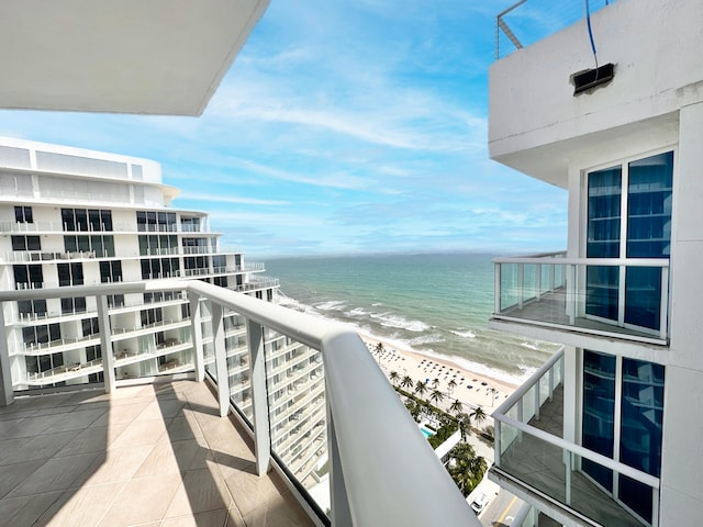 balcony featuring a beach view and a water view