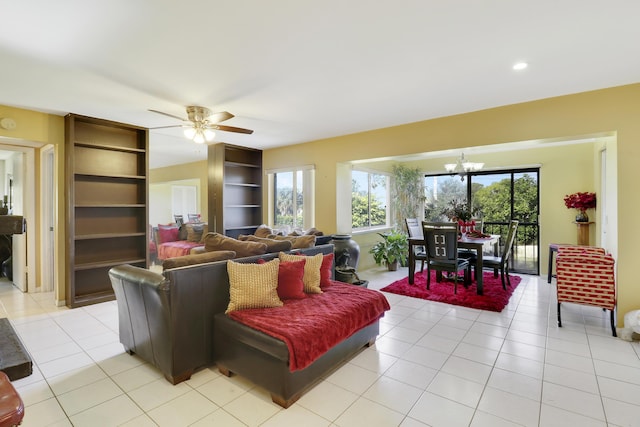 tiled living room featuring ceiling fan with notable chandelier and built in features