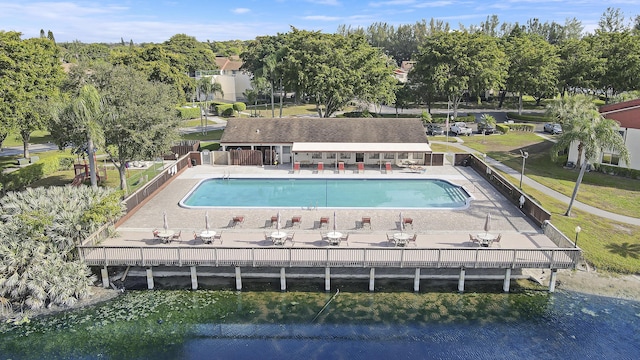 view of swimming pool featuring a patio and a water view