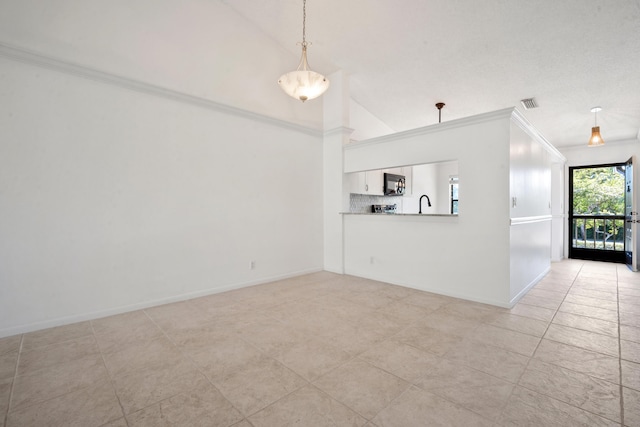 unfurnished room featuring sink, light tile patterned floors, and vaulted ceiling