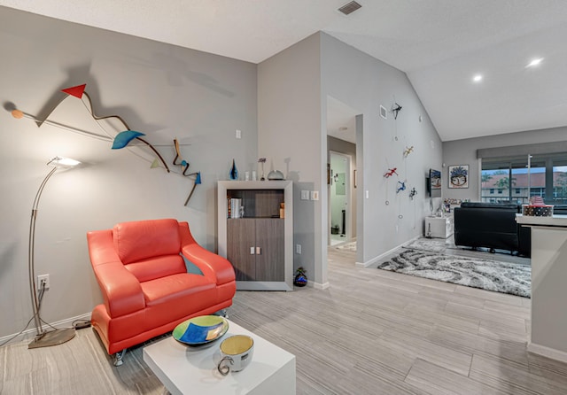 living room with light wood-type flooring and vaulted ceiling