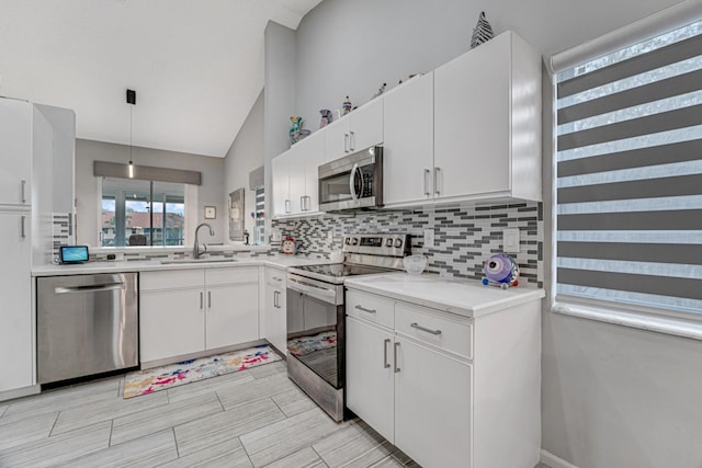 kitchen featuring pendant lighting, white cabinets, sink, tasteful backsplash, and stainless steel appliances