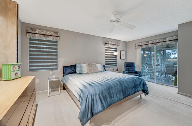 bedroom featuring ceiling fan, access to exterior, light colored carpet, and a textured ceiling