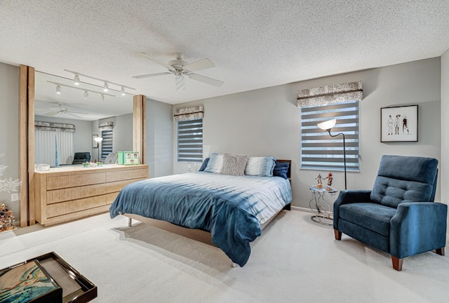 bedroom featuring multiple windows, ceiling fan, carpet, and a textured ceiling