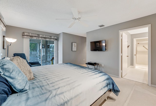 bedroom with access to exterior, ceiling fan, light colored carpet, and a textured ceiling