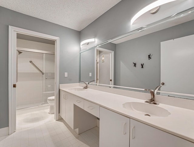 bathroom with a shower with door, vanity, a textured ceiling, and toilet