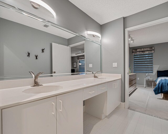 bathroom featuring tile patterned floors, vanity, and a textured ceiling