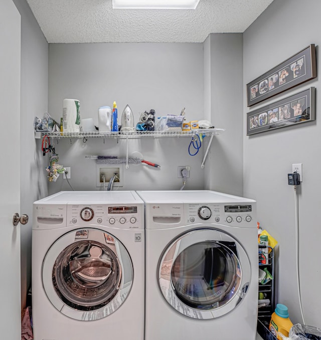 washroom featuring a textured ceiling and washer and clothes dryer